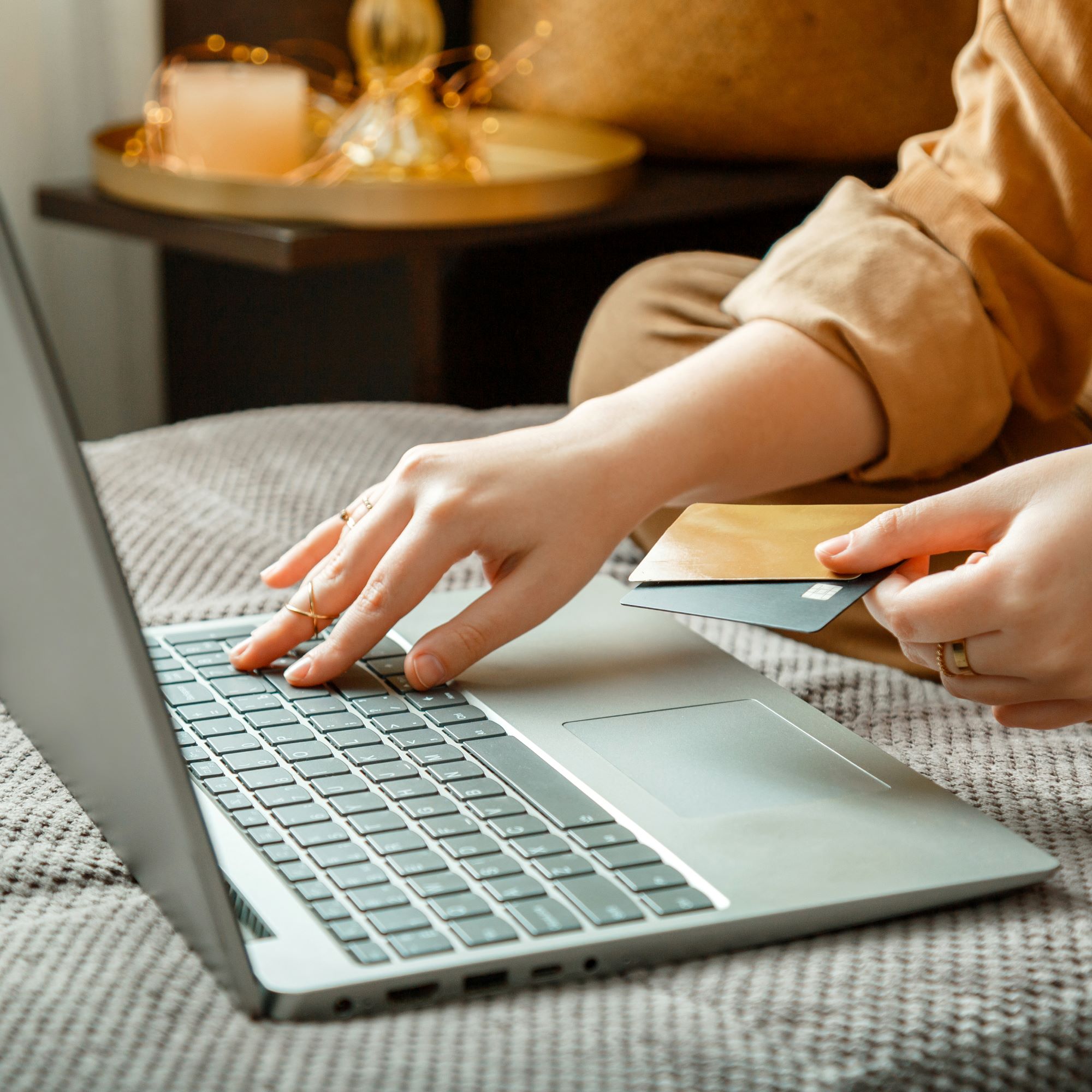Person using a laptop to make an online purchase, holding a credit card, symbolizing digital marketing and e-commerce education.